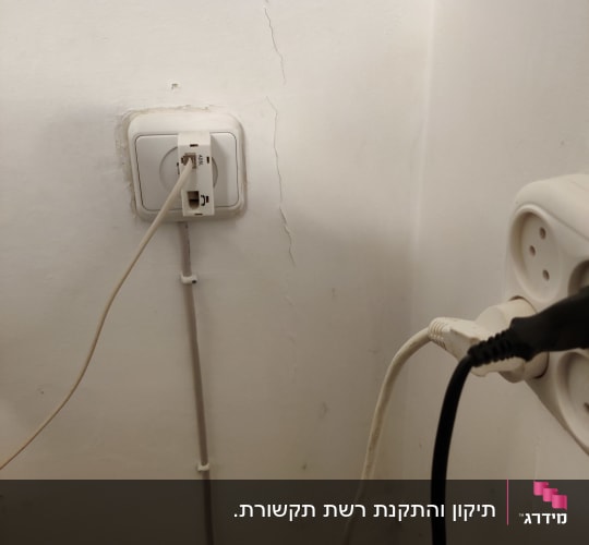 שקע תקשורת ותשתית בזק על קיר עם מתאם ADSL מחובר